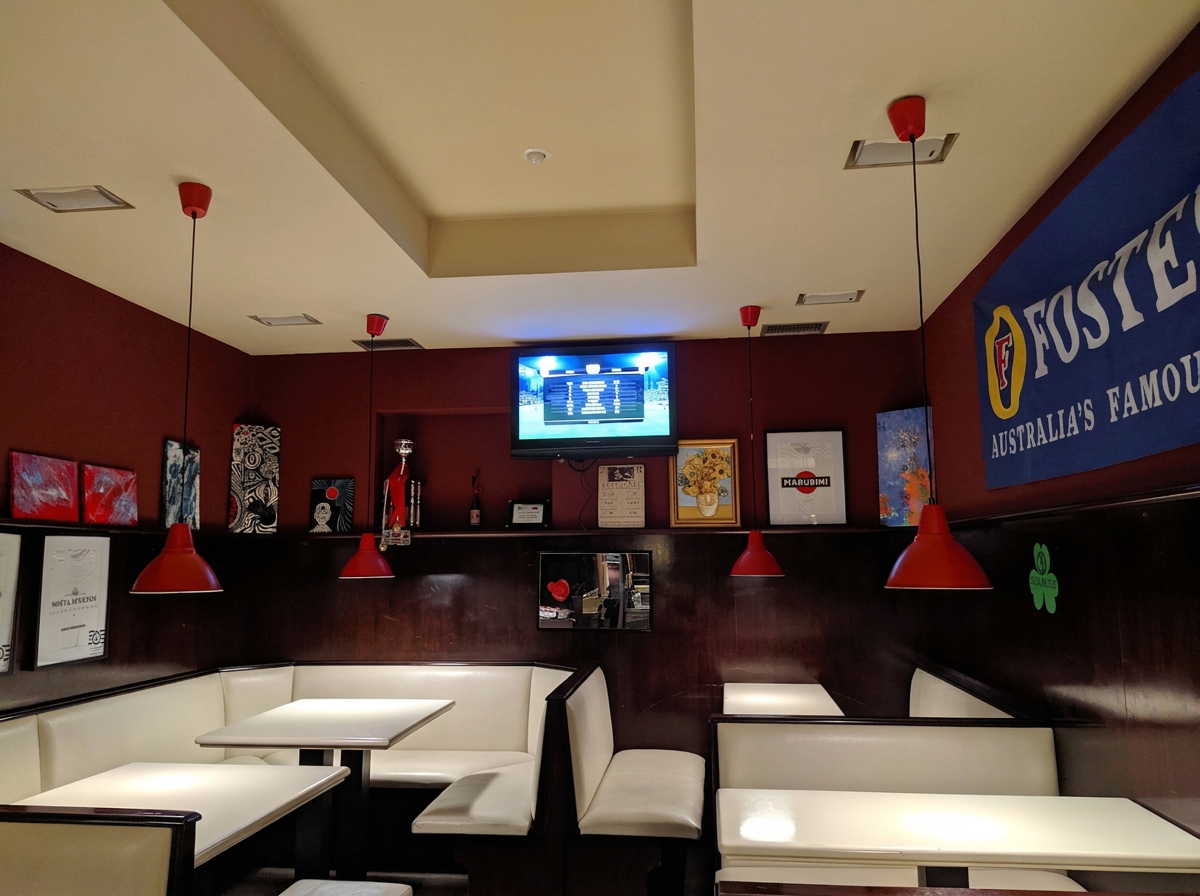 La sala del SAX con tavoli, divanetti e lampade rosse